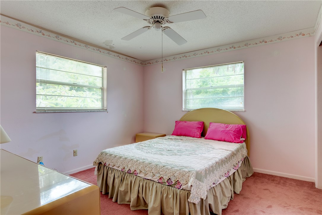 325 Perch Lane Sebastian, FL 32958 - Photo 15 of 26 a bedroom with a bed a chandelier and a window