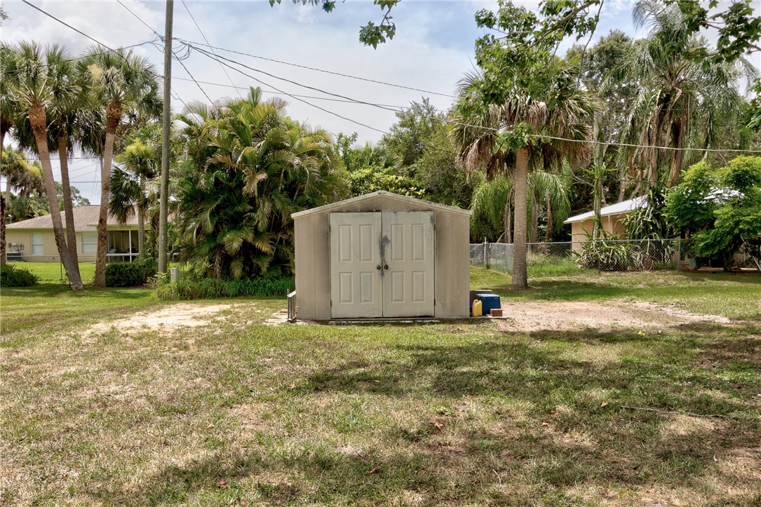 325 Perch Lane Sebastian, FL 32958 - Photo 24 of 26 a backyard of a house with large trees and plants