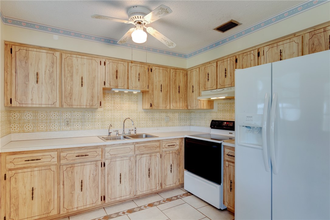 325 Perch Lane Sebastian, FL 32958 - Photo 8 of 26 a kitchen with white cabinets and white appliances