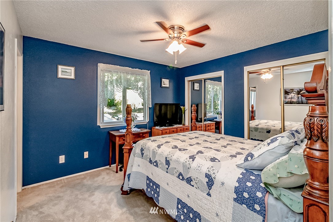 15911 OK Mill Road Snohomish, WA 98290 - Photo 14 of 40 a bedroom with a bed and a chandelier
