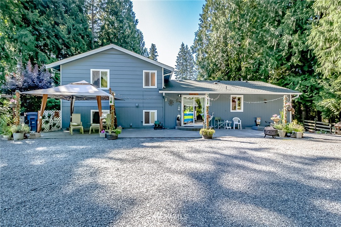 15911 OK Mill Road Snohomish, WA 98290 - Photo 3 of 40 a patio with a table and chairs under an umbrella