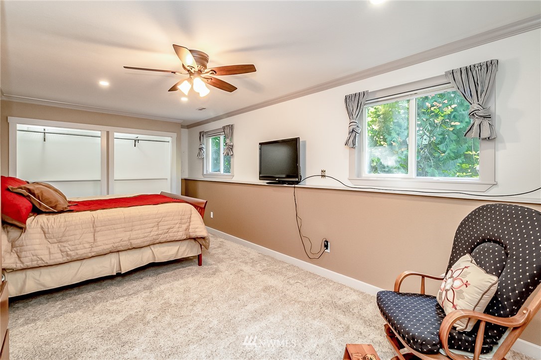 15911 OK Mill Road Snohomish, WA 98290 - Photo 23 of 40 a bedroom with a bed window and a flat screen tv