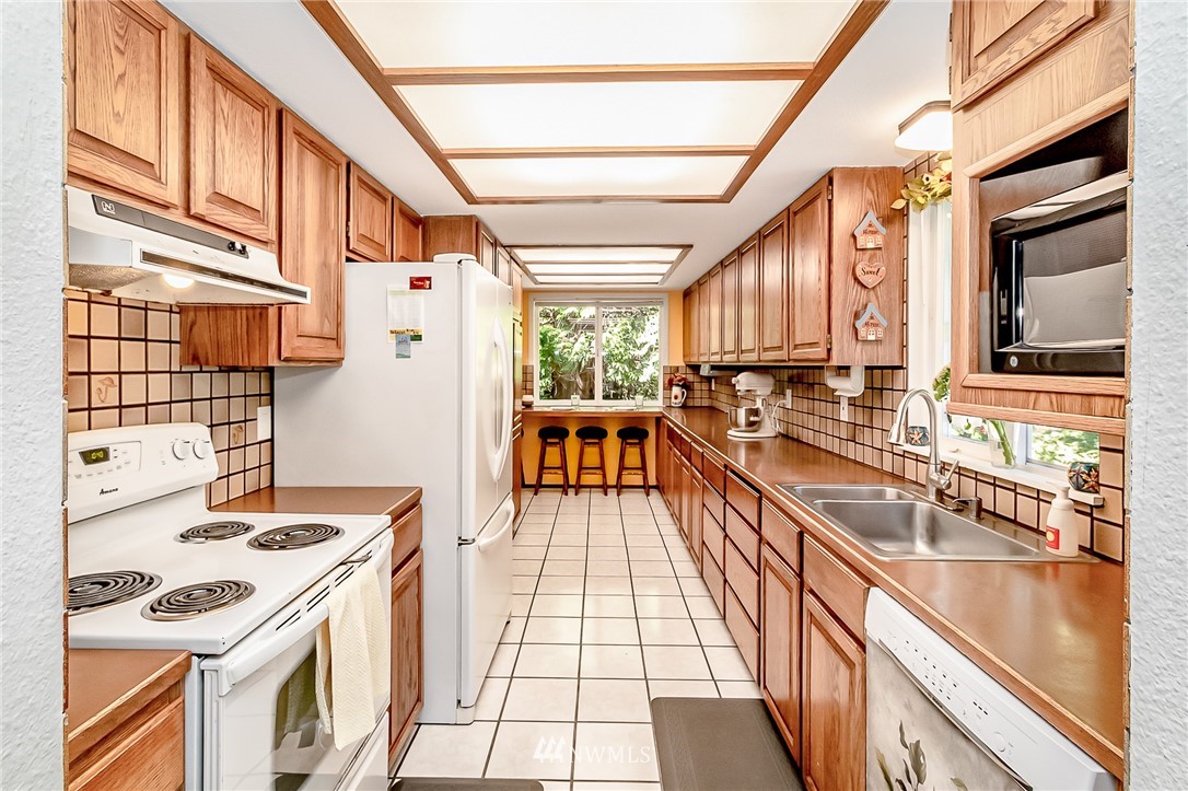 15911 OK Mill Road Snohomish, WA 98290 - Photo 6 of 40 a kitchen with a sink a stove and a refrigerator