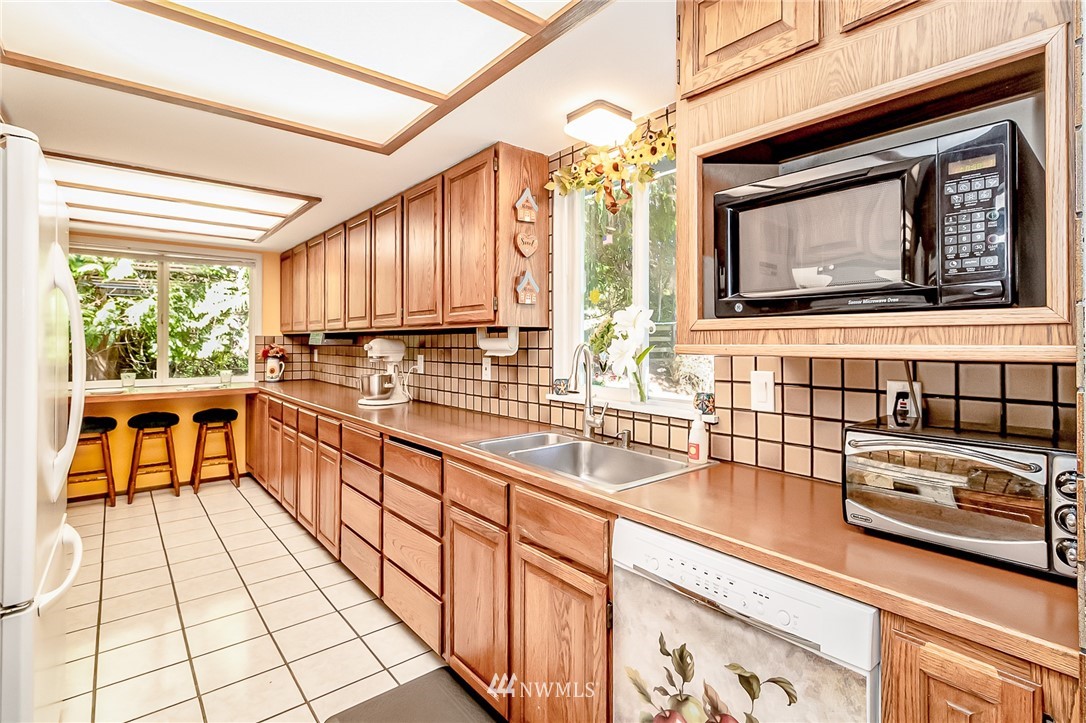 15911 OK Mill Road Snohomish, WA 98290 - Photo 7 of 40 a kitchen with stainless steel appliances kitchen island granite countertop a sink and cabinets