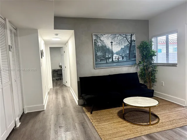 a view of a bedroom with a bed and wooden floor