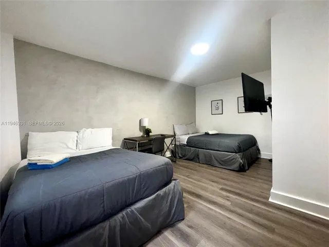 a bedroom with a bed a flat screen tv and view