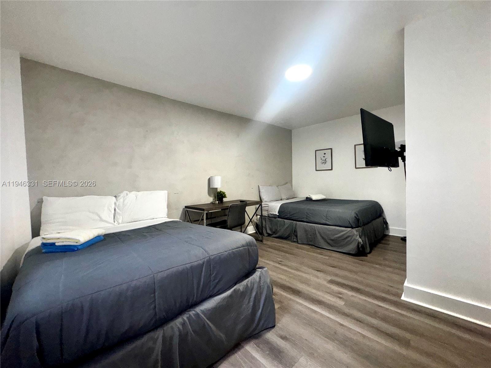 1684 Southwest 10th Street, Unit 5 Miami, FL 33135 - Photo 7 of 10 a bedroom with a bed a flat screen tv and view