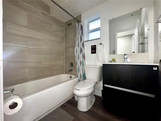 a bathroom with a sink a toilet a mirror and shower
