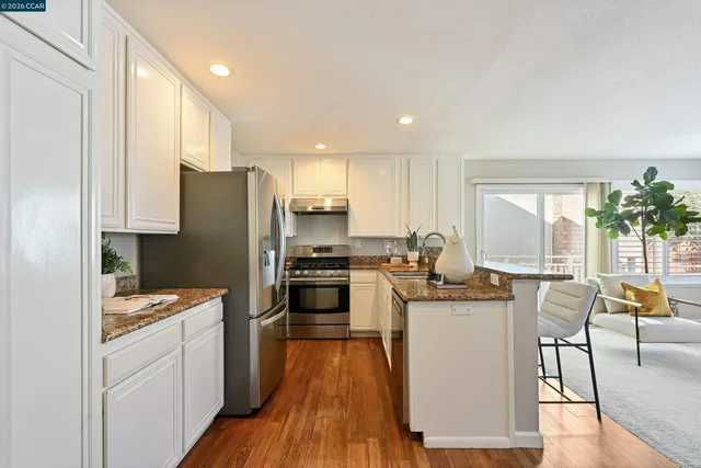 a kitchen with granite countertop a refrigerator stove and sink