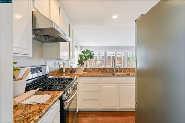 a kitchen with a sink appliances and wooden floor