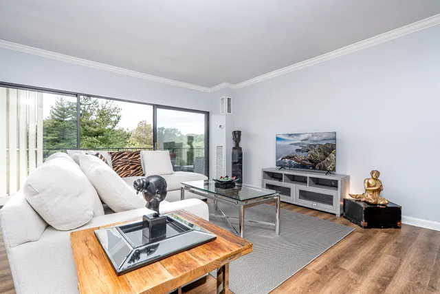 a living room with furniture large window and a flat screen tv