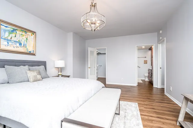 a spacious bedroom with a bed and wooden floor