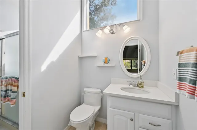 a bathroom with a sink mirror and toilet