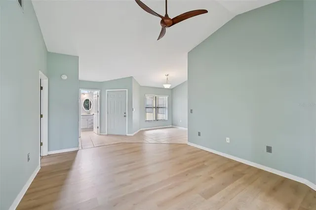 a view of an empty room with window and wooden floor