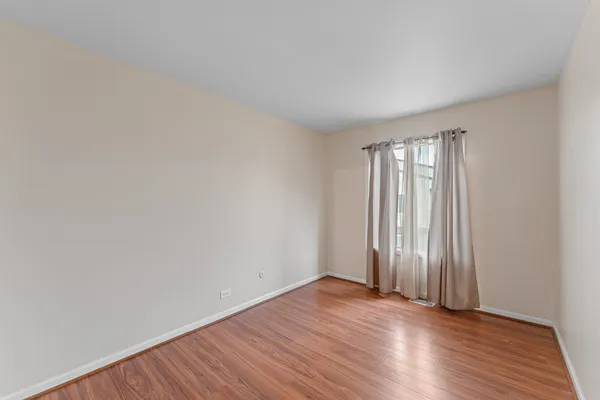 a view of a balcony with wooden floor and floor to ceiling window