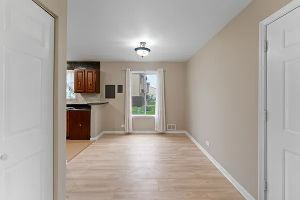 a view of a kitchen with wooden floor and electronic appliances