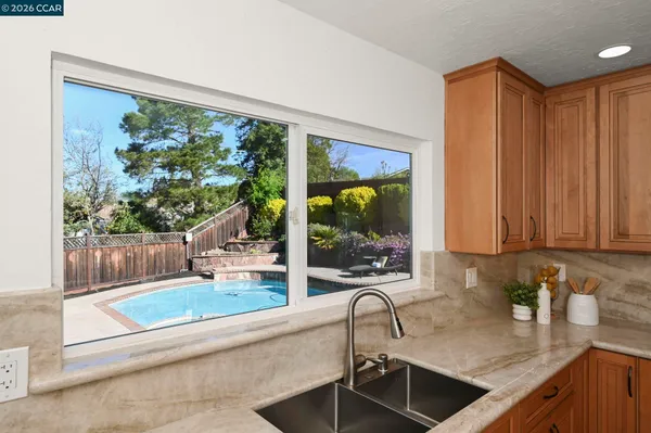 a kitchen with kitchen island a large counter top space a sink stainless steel appliances and cabinets
