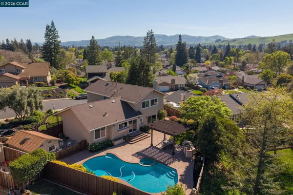 a view of a patio with table and chairs potted plants and large tree