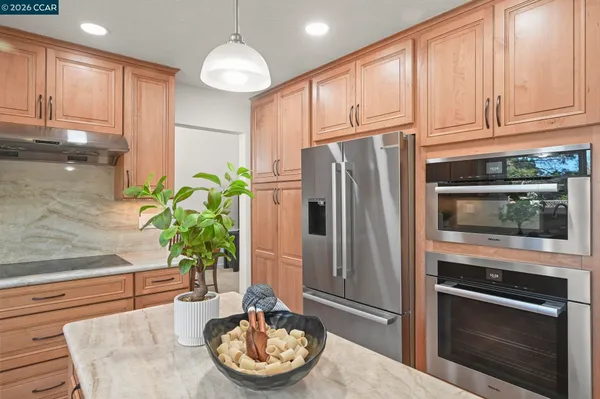 a kitchen with stainless steel appliances granite countertop a refrigerator a stove a microwave and cabinets