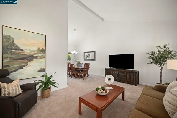 a living room with furniture a flat screen tv and a large window