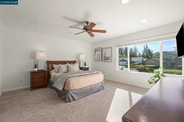 a spacious bedroom with a bed couch and a large window