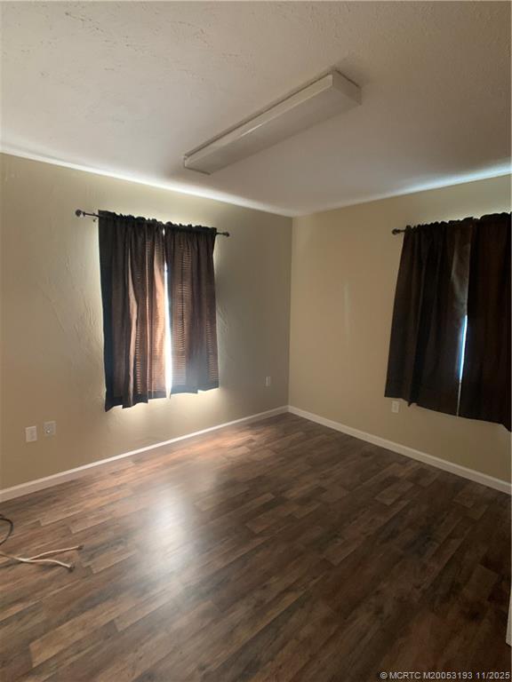 6105 Southwest Gator Trail, Unit A Palm City, FL 34990 - Photo 15 of 19 an empty room with wooden floor and windows