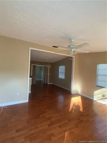 a view of a livingroom with wooden floor and a kitchen