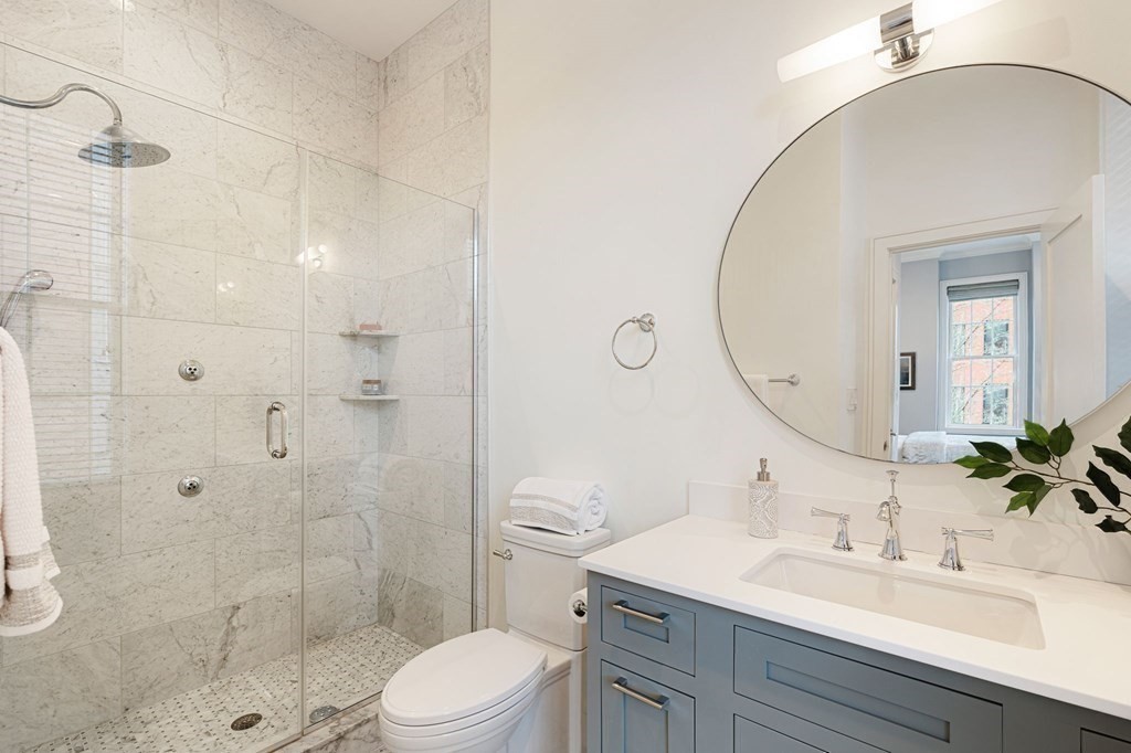 11 Exeter Street, Unit 5 Boston, MA 02116 - Photo 10 of 13 a bathroom with a sink toilet a mirror and shower