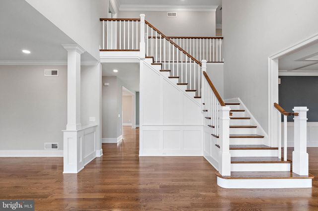a kitchen with stainless steel appliances kitchen island wooden cabinets and wooden floors