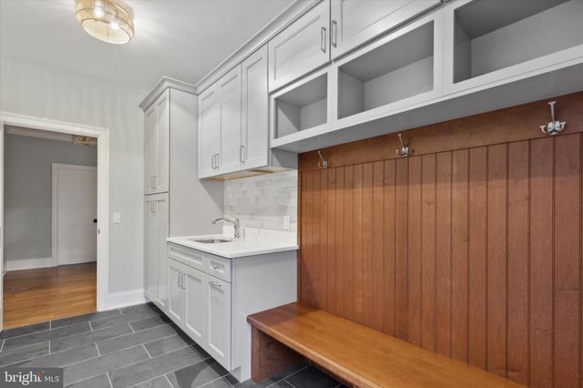 a bathroom with a toilet a sink a mirror and a window