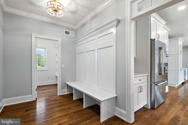 a view of an empty room with kitchen and a window