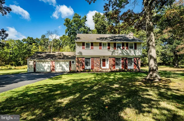 a view of a house with a big yard potted plants and large tree