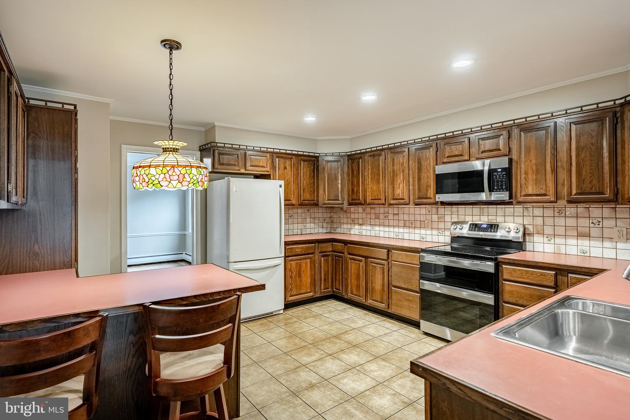 8 Andrews Road Malvern, PA 19355 - Photo 21 of 62 a kitchen with stainless steel appliances granite countertop a stove refrigerator sink and microwave
