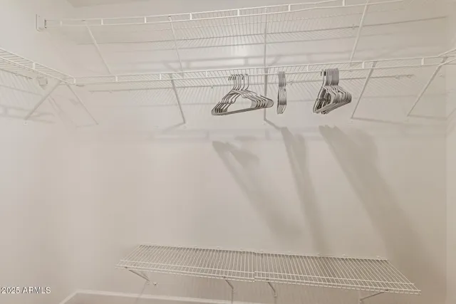 a bedroom with a large bed a flat screen tv and a dresser