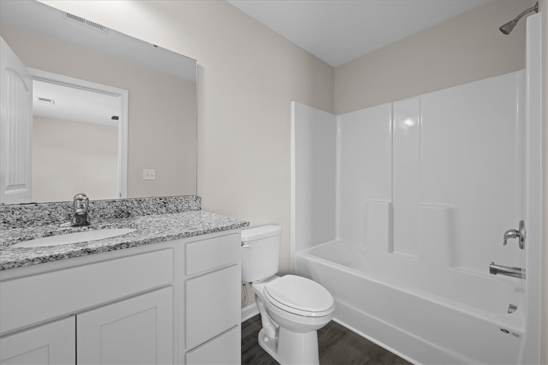 115 Adger Road Pendleton, SC 29670 - Photo 19 of 36 A well-appointed bathroom features a practical vanity with a granite countertop and a combination shower-tub.