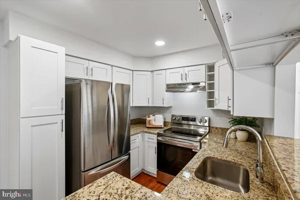 a kitchen with stainless steel appliances granite countertop a stove a refrigerator and a refrigerator