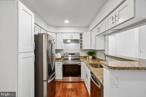 a kitchen with granite countertop a sink stove and refrigerator