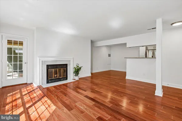 a view of empty room with wooden floor and window