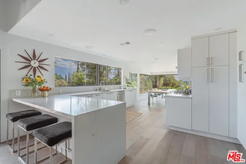 a view of a swimming pool with lawn chairs under an umbrella