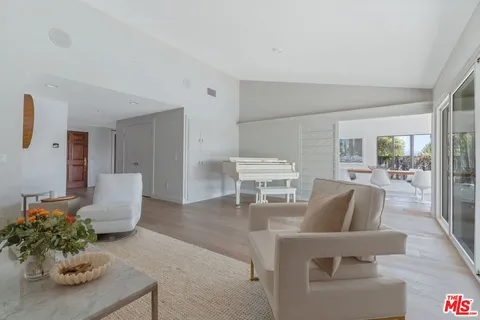 a living room with furniture wooden floor and a large window