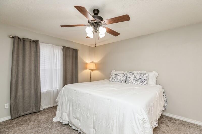 264 Limestone Circle Crestview, FL 32539 - Photo 19 of 38 a bedroom with a large bed and a chandelier