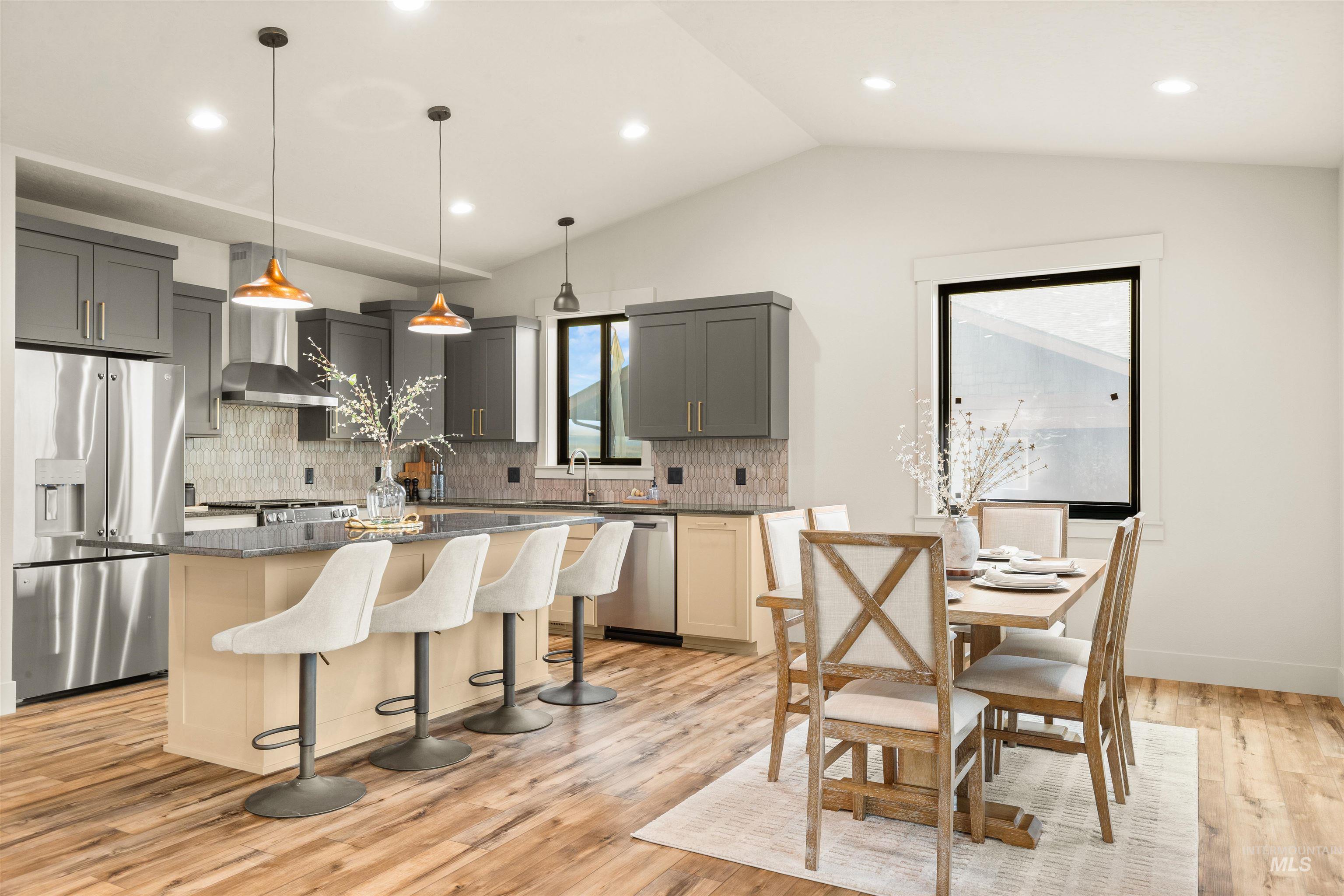 335 Warner Avenue Lewiston, ID 83501 - Photo 19 of 43 Kitchen featuring gray cabinetry, stainless steel appliances, a kitchen bar, decorative light fixtures, and a kitchen island