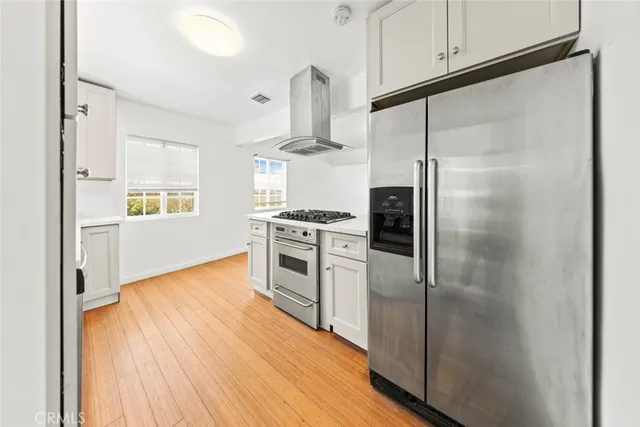 a kitchen with white cabinets and appliances