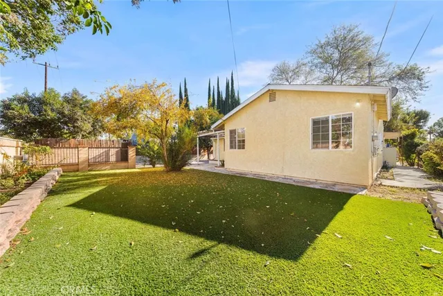 a view of a house with a tree and a yard
