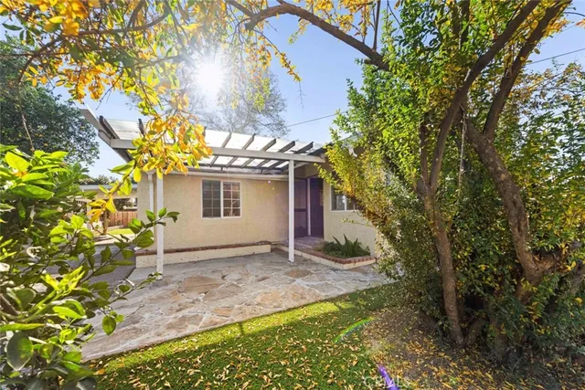 a view of a house with a yard and large tree
