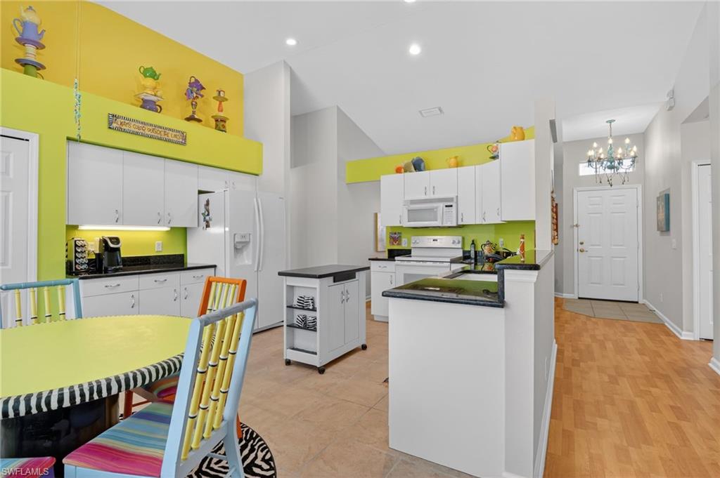 22818 Snaptail Court Estero, FL 33928 - Photo 26 of 37 a kitchen that has a lot of cabinets in it and wooden floor