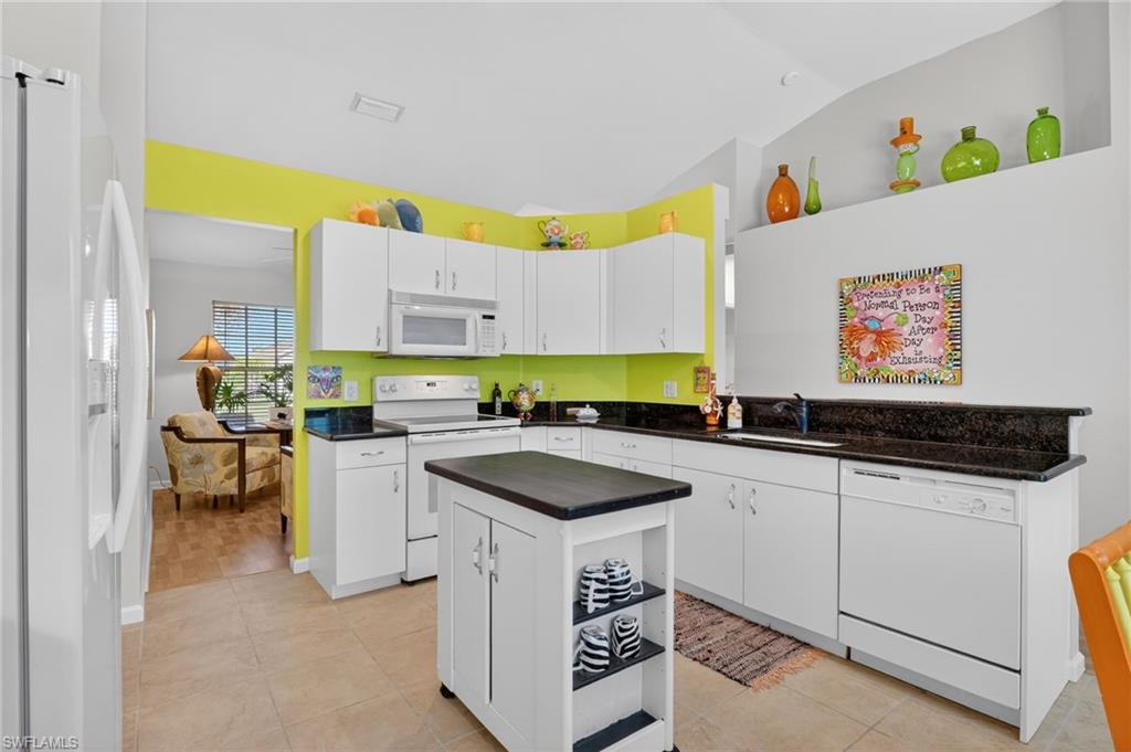 22818 Snaptail Court Estero, FL 33928 - Photo 28 of 37 a kitchen with granite countertop a sink a stove and cabinets