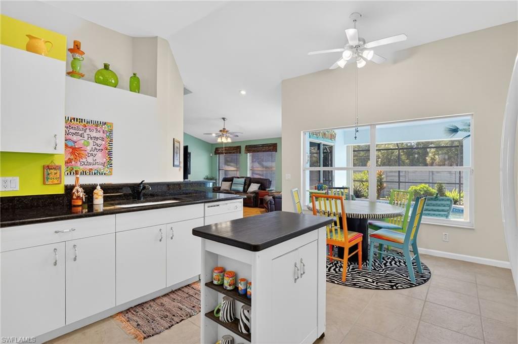 22818 Snaptail Court Estero, FL 33928 - Photo 37 of 37 a kitchen with stainless steel appliances granite countertop a stove a sink a dining table and chairs with wooden floor