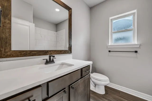 a bathroom with a sink toilet and mirror