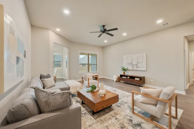 a living room with furniture and a wooden floor